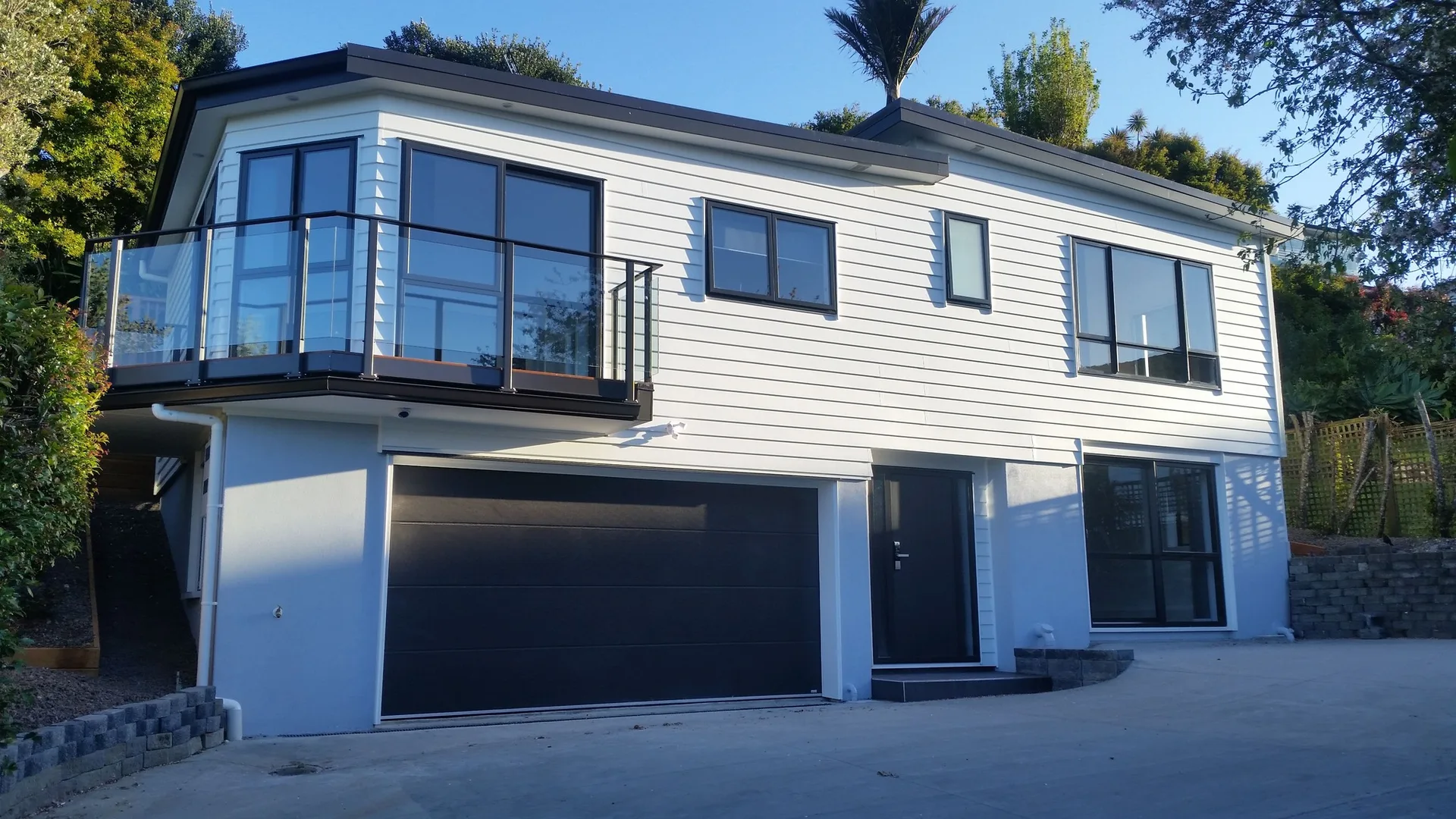 Modern two-storey home with black balcony and garage completed by JHJ Homes