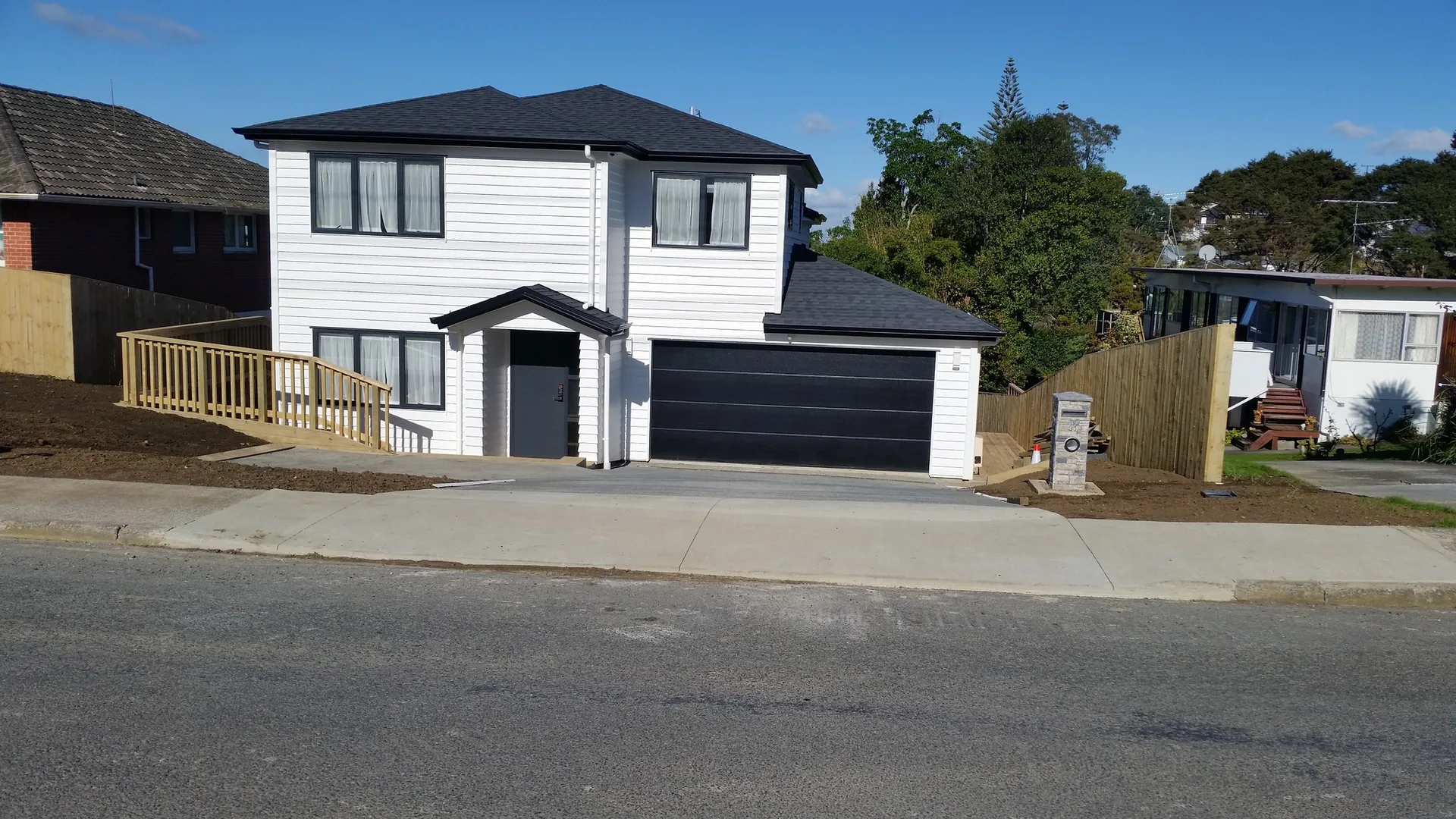 Completed white home with black garage and new deck by JHJ Homes
